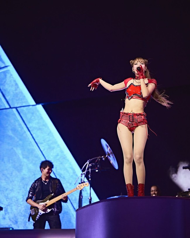 Lisa tampil seksi dan fierce dalam kostum merah menyala dengan sentuhan glitter. Potongan asimetris dan bahannya yang memantulkan cahaya membuat penampilannya makin memukau di bawah lampu panggung. Foto: dok. Instagram/@lalalalisa_