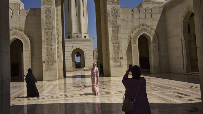 Mengunjungi Masjid Agung Sultan Qaboos Oman Tourists take photos at the Sultan Qaboos Grand Mosque in Muscat, Oman, Saturday, April 12, 2025. (AP Photo/ Fatima Shbair)