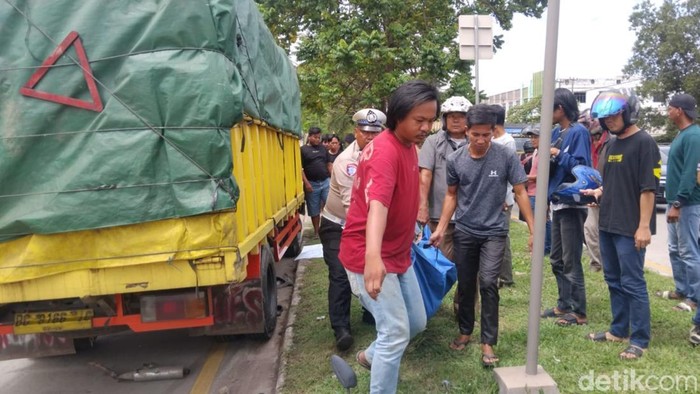 Polisi dibantu warga saat mengevakuasi korban laka lantas yang  meninggal dunia di lokasi kejadian.