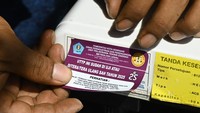 Petugas menempelkan stiker di timbangan milik pedagang yang sudah ditera ulang.  