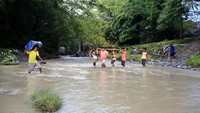 Warga terpaksa menyeberangi sungai karena jembatan yang menghubungkan Kecamatan Pulubala dan Tibawa ambruk.