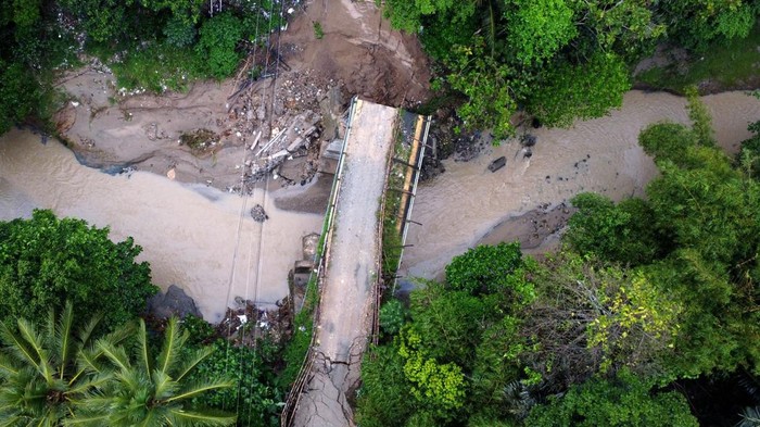 Jembatan yang menghubungkan Kecamatan Pulubala dan Tibawa di Gorontalo ambruk usai tergerus arus sungai yang meluap akibat hujan deras. Begini penampakannya.