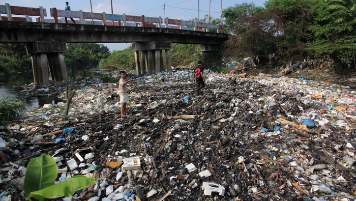 Warga mencari barang bekas di sungai yang tercemar limbah sampah di Desa Pematang Johar, Kecamatan Labuhan Deli, Kabupaten Deli Serdang, Sumatera Utara, Selasa (15/4/2025). Menurut warga, sungai tersebut tercemar limbah sampah rumahan dan limbah dari pabrik yang mengakibatkan bau tak sedap dan warna air menjadi hitam.