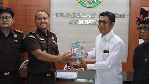 Kejari Jembrana saat menyerahkan uang pengganti sebesar Rp 301 juta kepada LPD Yehembang Kauh di Kantor Kejari Jembrana, Rabu (16/4/2025).