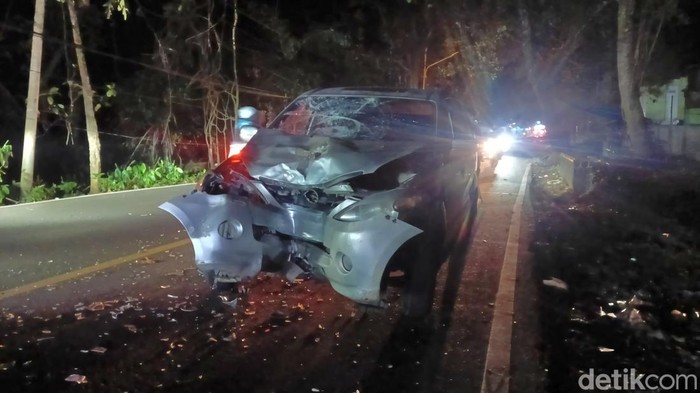 Mobil hancur bagian depannya usah bertabrakan dengan sepeda motor.