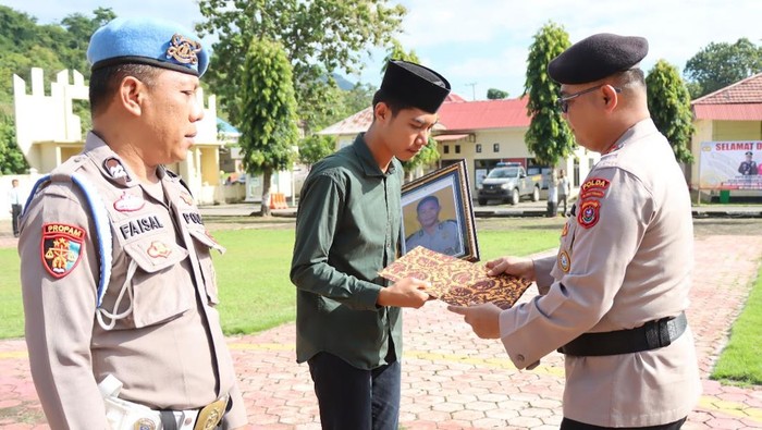Perwakilan keluarga almarhum Fajar Iwu saat menerima pangkat kehormatan menjadi Anumerta Aiptu Fajar Iwu.