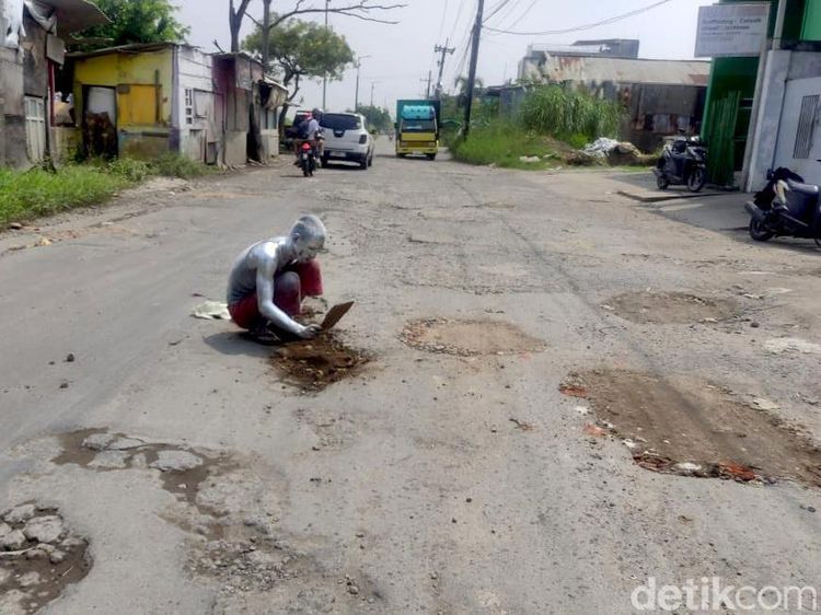 Aksi Manusia Silver Protes Jalan Rusak di Sidoarjo
