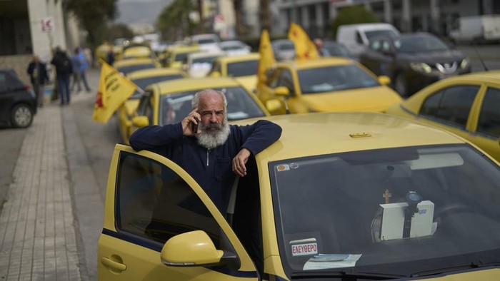 Ratusan Taksi Mengular di Jalanan Yunani Selama Aksi Mogok Taxi drivers drive their vehicles along a central road to protest against regulations affecting their industry during a one day strike in Athens, Greece, Tuesday, April 15, 2025.(AP Photo/Petros Giannakouris)