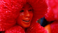Pemuda dan pria Hindu melukis diri mereka dengan warna merah. 
