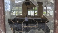 Guru berdiri di dalam ruangan bekas laboratorium yang rusak di SMPN 22 Muaro Jambi, Desa Sungai Bungur, Muaro Jambi, Jambi, Rabu (16/4/2025).  