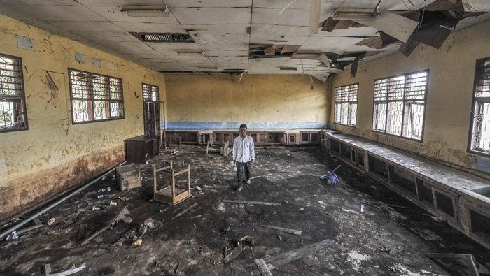 Guru berjalan di dalam ruangan bekas laboratorium yang rusak di SMPN 22 Muaro Jambi, Desa Sungai Bungur, Muaro Jambi, Jambi, Rabu (16/4/2025). Sebanyak lima ruangan termasuk laboratorium dan perpustakaan di sekolah yang memiliki 46 murid dan setiap tahunnya terdampak banjir luapan Sungai Batanghari tersebut rusak sedang hingga berat sehingga tidak bisa difungsikan sejak 2020. ANTARA FOTO/Wahdi Septiawan/wpa.