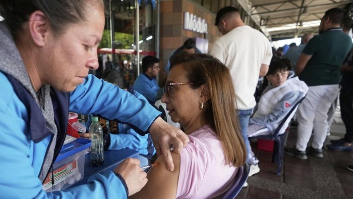 A health worker prepares a yellow fever vaccine to inoculate travelers at the bus terminal in Bogota, Colombia, Wednesday, April 16, 2025. (AP Photo/Fernando Vergara)