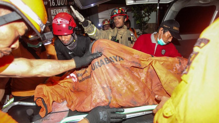 Sejumlah petugas mengevakuasi jenazah korban kebakaran rumah toko di Jalan Kedung Rukem IV, Surabaya, Jawa Timur, Kamis (17/4/2025). Sebanyak 15 kendaraan pemadam kebakaran dikerahkan untuk memadamkan kebakaran ruko di kawasan pemukiman padat penduduk yang menewaskan dua orang penghuninya itu.