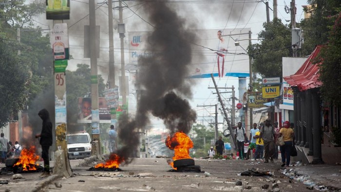 Kekerasan Geng Meningkat di Haiti, Warga Protes Desak Pemerintah Bertindak A man rides his motorcycle past a burning barricade during a protest against insecurity, in Port-au-Prince, Haiti, April 16, 2025. REUTERS/Fildor Pq Egeder TPX IMAGES OF THE DAY
