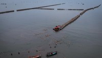 Foto udara pekerja menggunakan alat berat saat membongkar pagar laut di pesisir laut Desa Kohod, Kabupaten Tangerang, Banten, Kamis (17/4/2025).