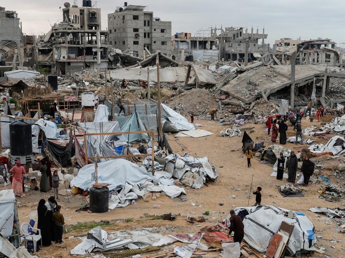 A Palestinian man inspects the damage at the site of an Israeli strike on a tent camp sheltering displaced people, in Khan Younis in the southern Gaza Strip April 17, 2025. REUTERS/Hatem Khaled