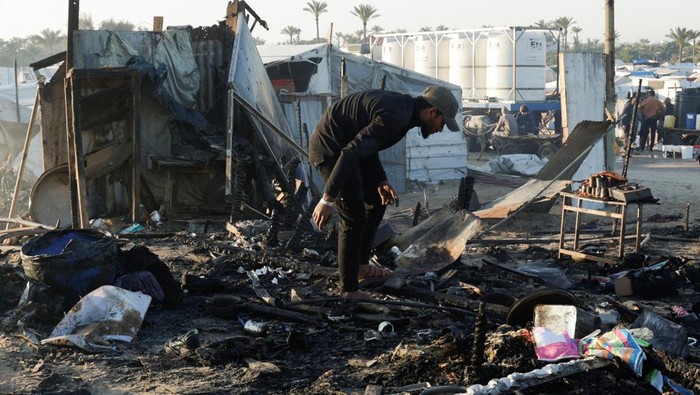 Penampakan Tenda-tenda Pengungsi Palestina Hancur Diserang Israel A Palestinian man inspects the damage at the site of an Israeli strike on a tent camp sheltering displaced people, in Khan Younis in the southern Gaza Strip April 17, 2025. REUTERS/Hatem Khaled