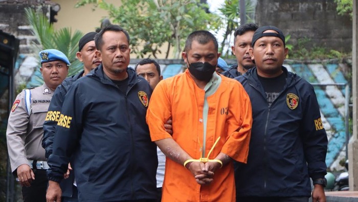 Polisi menggiring Juniawan, penjambret viral di Gianyar, Bali.
