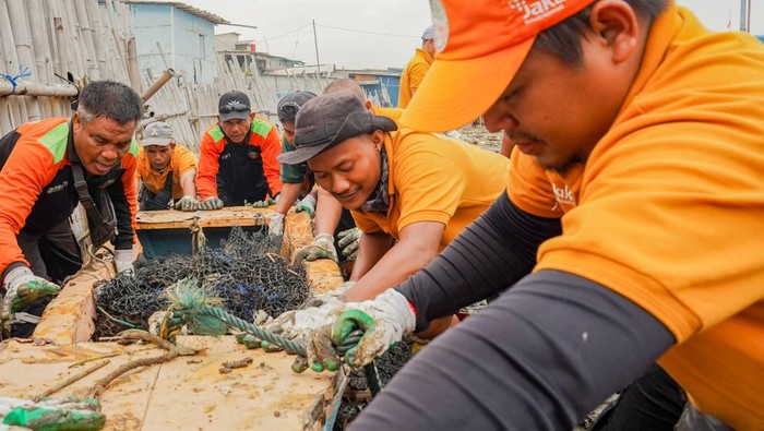 Petugas Suku Dinas Lingkungan Hidup Kepulauan Seribu memindahkan kapal yang terbawa arus di Area Tanggul Dermaga Ujung Pluit, Penjaringan, Jakarta, Kamis (17/4/2025). Petugas mengatakan sampah tersebut berasal dari sampah kiriman yang terbawa ombak serta terdapat sampah dari docking kapal dan warga yang mengakibatkan pencemaran lingkungan.ANTARA FOTO/Ferlian Septa Wahyusa/foc.