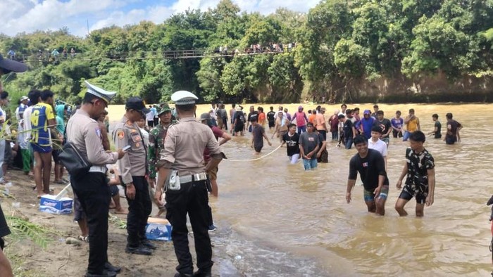 Warga bersama petugas Polres Enrekang di lokasi mobil terjun ke Sungai Mamasa, Kabupaten Enrekang.