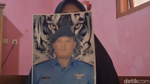 Ibunda Rizal memegang Foto Rizal yang mengenakan seragam sekolah pelayaran.