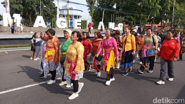 Ibu-ibu memakai kebaya berjalan mengikuti kirab salib Magelang, Jumat (18/4/2025).