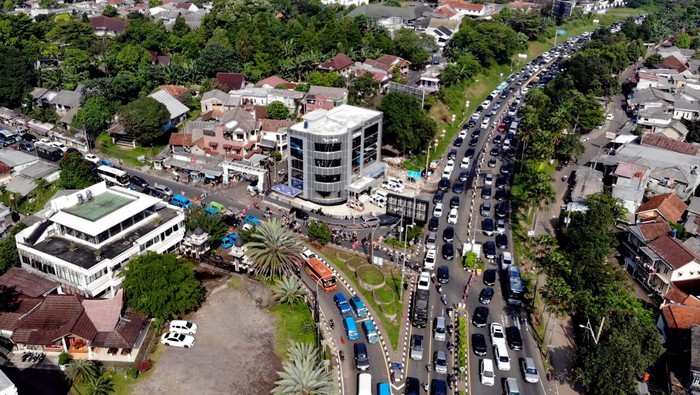 Libur Panjang, Jalur Wisata Puncak Padat Merayap Foto udara kepadatan kendaraan saat diberlakukan sistem satu arah menuju jalur wisata Puncak, Gadog, Kabupaten Bogor, Jawa Barat, Jumat (18/4/2025). Polres Bogor melakukan rekayasa lalu lintas sistem satu arah dan sistem lawan arus di pintu keluar Tol Ciawi serta sistem ganjil genap untuk mengurai kepadatan kendaraan wisatawan yang menuju jalur wisata Puncak saat libur Paskah dan libur akhir pekan. ANTARA FOTO/Yulius Satria Wijaya/tom.