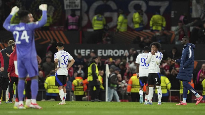 Lyons Malick Fofana, right, reacts after the Europa League quarter final second leg soccer match between Manchester United and Olympique Lyon in Manchester, Britain, Thursday, April 17, 2025. (AP Photo/Jon Super)