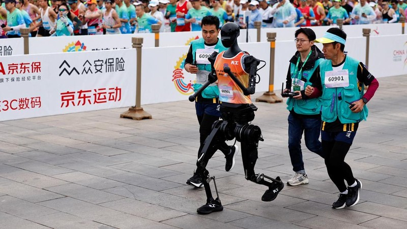 Tiangong Ultra, a humanoid robot runs across the finish line while securing the first position during the E-Town Humanoid Robot Half Marathon, in Beijing, China April 19, 2025. REUTERS/Tingshu Wang