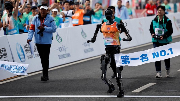 Tiangong Ultra, a humanoid robot runs across the finish line while securing the first position during the E-Town Humanoid Robot Half Marathon, in Beijing, China April 19, 2025. REUTERS/Tingshu Wang