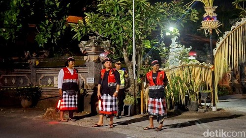 Pecalang turut berjaga mengamankan misa Malam Paskah di depan Gereja Katolik Tritunggal Mahakudus, Tuka, Dalung, Kuta Utara, Badung. Sabtu (19/4/2025). (Foto: Fabiola Dianira/detikBali)