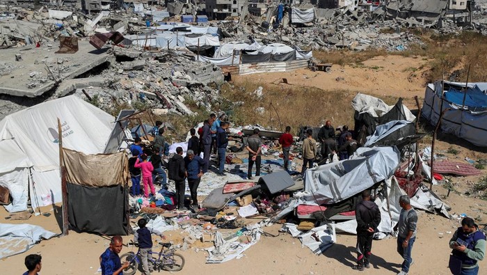 People gather at the site where Palestinian man Ghassan Asaliya, his wife and all their 5 children were killed in an Israeli strike on their tent where they sheltered, according to medics, in Jabalia refugee camp in the northern Gaza Strip April 17, 2025. REUTERS/Mahmoud Issa