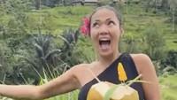 Wanita 46 tahun ini tengah menikmati pemandangan sawah hijau di Bali sambil minum air kelapa langsung dari batoknya. Ia juga memutar lagu Mahadaya Cinta yang dilantunkannya. Foto: Instagram shantyofficial