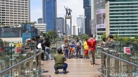 Sejumlah warga berfoto di Skydeck Halte Transjakarta Bundaran HI, Sabtu (19/4/2025).