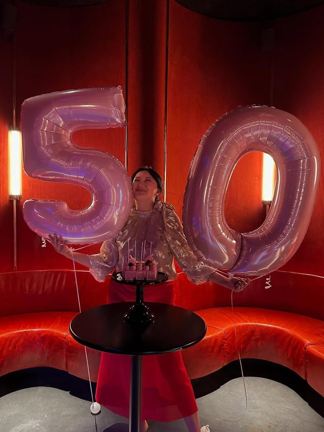 Dalam kesempatan itu, Tata Cahyani tampak sumringah menyambut fase baru dalam kehidupannya selagi mengenakan atasan bernuansa gold dan rok merah. Foto: Instagram @tatacahyani