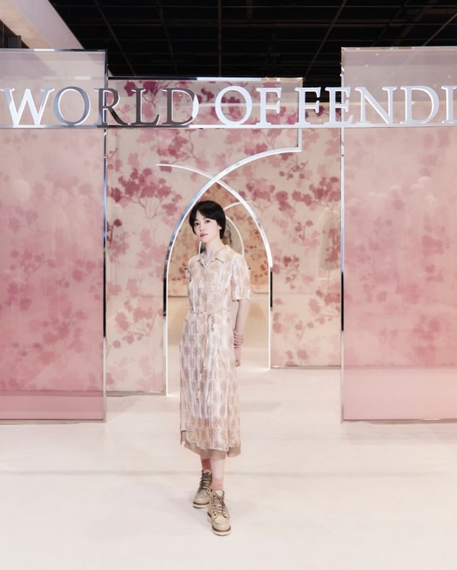 Gaun tersebut dipadukan sepatu boots Fendi berwarna beige dan kaos kaki berwarna pink, melengkapi keseluruhan gaya semi androgini Song Hye Kyo. Foto: dok. Instagram @kyo1122