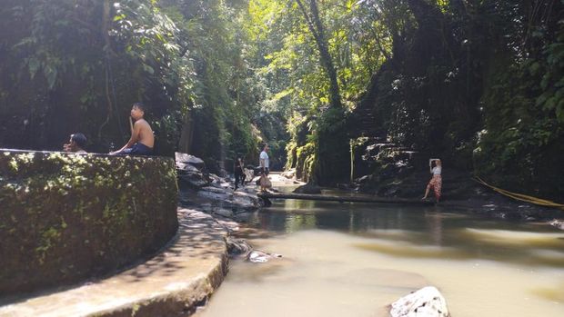 Wisatawan berfoto di jembatan bambu di kawasan objek wisata Air Terjun Kantolampo, Gianyar, Bali, Sabtu (12/4/2025).