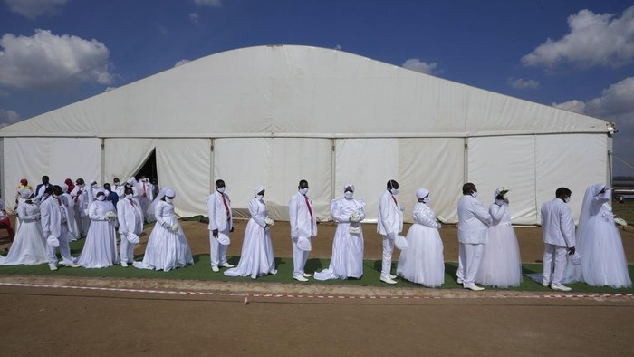 3 Ribu Orang Menikah Massal di Afsel Saat Perayaan Paskah A man with his wife and two of his brides sits inside a marquee ahead of the mass Easter weddings for 3,000 people, some polygamous, at the International Pentecost Holiness Church in Heidelberg, east of Johannesburg, South Africa, Sunday, April 20, 2025. (AP Photo/Themba Hadebe)