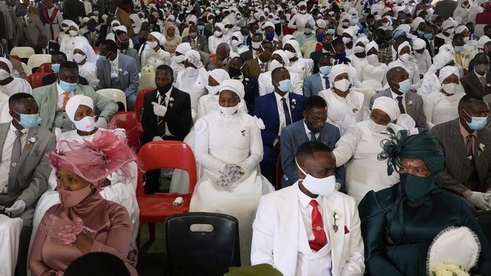 A man with his wife and two of his brides sits inside a marquee ahead of the mass Easter weddings for 3,000 people, some polygamous, at the International Pentecost Holiness Church in Heidelberg, east of Johannesburg, South Africa, Sunday, April 20, 2025. (AP Photo/Themba Hadebe)