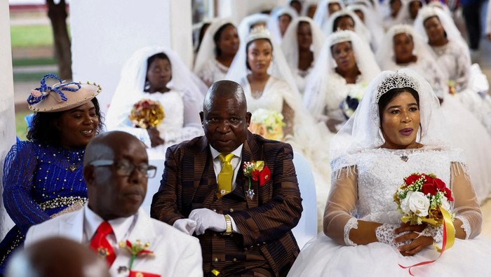 54 Pasangan Termasuk Penganut Poligami Nikah Massal Brides and bridegrooms arrive to take part in a mass wedding ceremony at the International Pentecostal Holiness Church (IPHC) in Zuurbekom, west of Johannesburg, South Africa, April 20, 2025. As part of Easter celebrations, over 54 couples, including first-time and polygamous unions, exchanged vows. REUTERS/Siphiwe Sibeko
