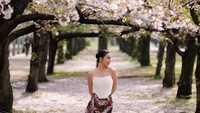 Ariel tatum membagikan foto-foto di tengah kebun sakura dengan keterangan,Suatu hari pukul delapan pagi. Melihat bunga sakura untuk pertama kalinya. Bertepatan dengan fase bulan purnama di Osaka. (Instagram Ariel Tatum)