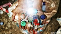 Seorang pekerja memperlihatkan sampah tutup botol. Anak-anak dari Yayasan Kumala kini telah memberikan training di instansi pemerintah, komunitas, dan perusahaan swasta.  