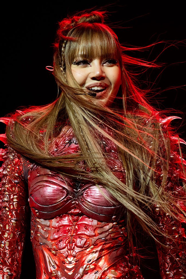 Rambutnya ditata half-updo dengan aksen kepang, dipadukan riasan smokey eyes dan bibir merah yang memberikan kesan sensual dan fierce. Foto: Getty Images