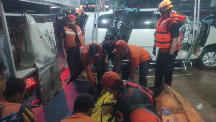 Petugas BPBD Lampung saat mengevakuasi warga yang tewas terdampak banjir