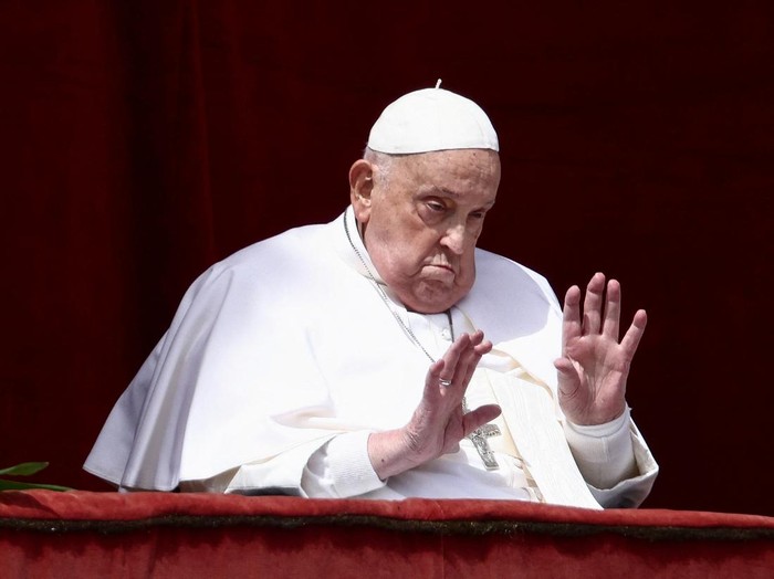 Pope Francis gestures from a balcony as the 