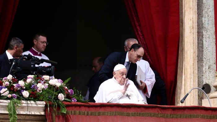 Pope Francis gestures from a balcony as the 