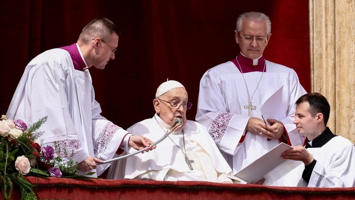 Pope Francis gestures from a balcony as the 