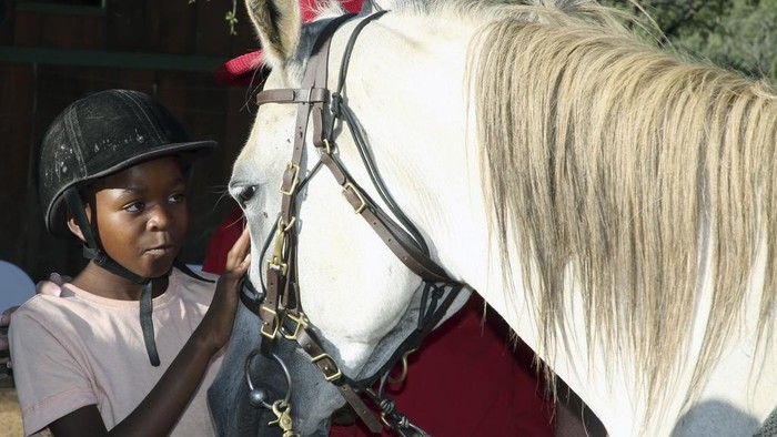 Susan de Meyer, right, and Immanuel Hoxobeb assist children participating in the 
