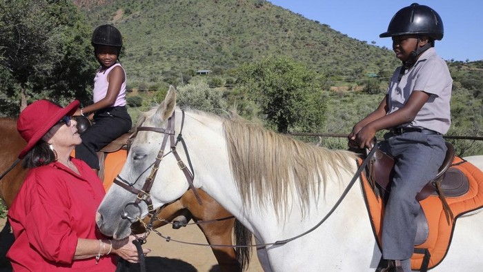 Susan de Meyer, right, and Immanuel Hoxobeb assist children participating in the 