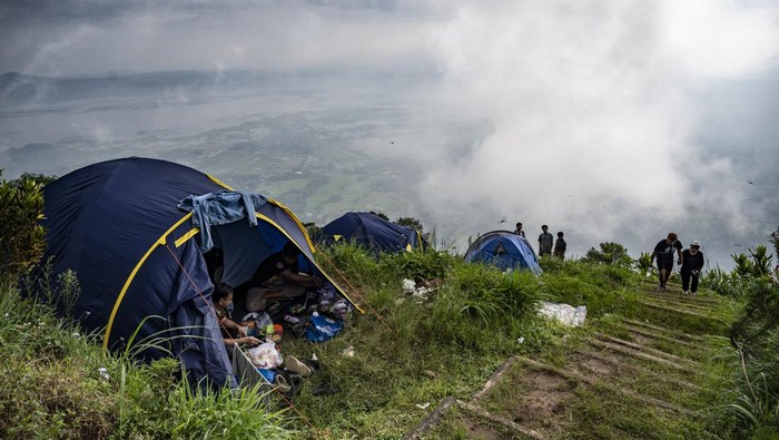 Sejumlah pengunjung melihat Danau Rawa Pening dari puncak Gunung Gajah Telomoyo di Nogosaren, Getasan, Kabupaten Semarang, Jawa Tengah, Minggu (20/4/2025). Objek wisata Gunung Gajah Telomoyo dengan ketinggian 1.300 mdpl itu menjadi salah satu destinasi wisata unggulan di Kabupaten Semarang yang menjadi tujuan favorit wisatawan saat akhir pekan dan libur panjang. ANTARA FOTO/Aprillio Akbar/rwa.